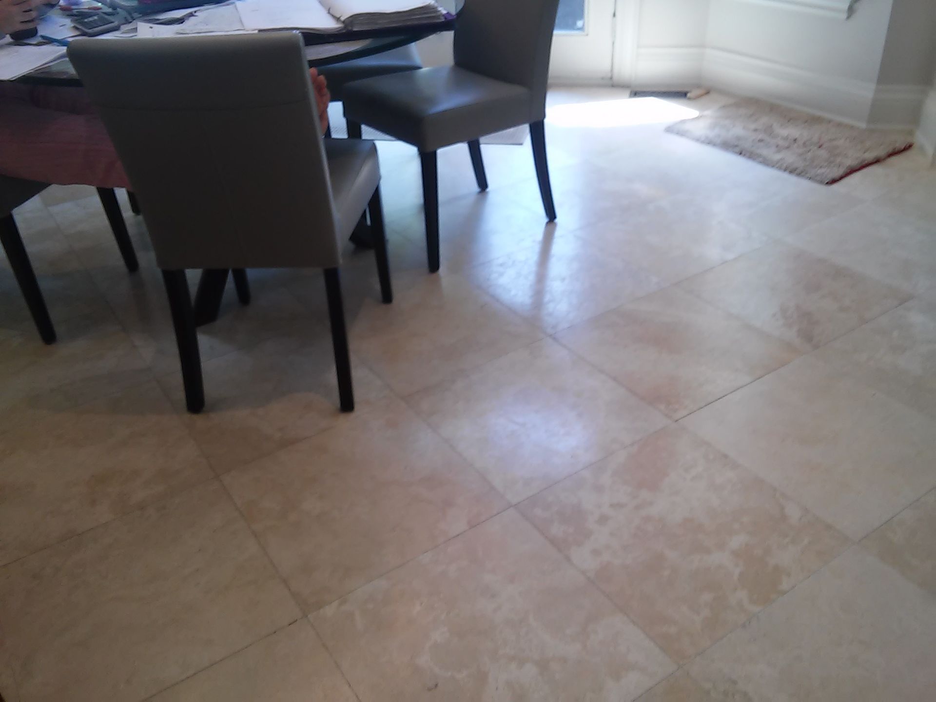 A dining room with a table and chairs and a tiled floor