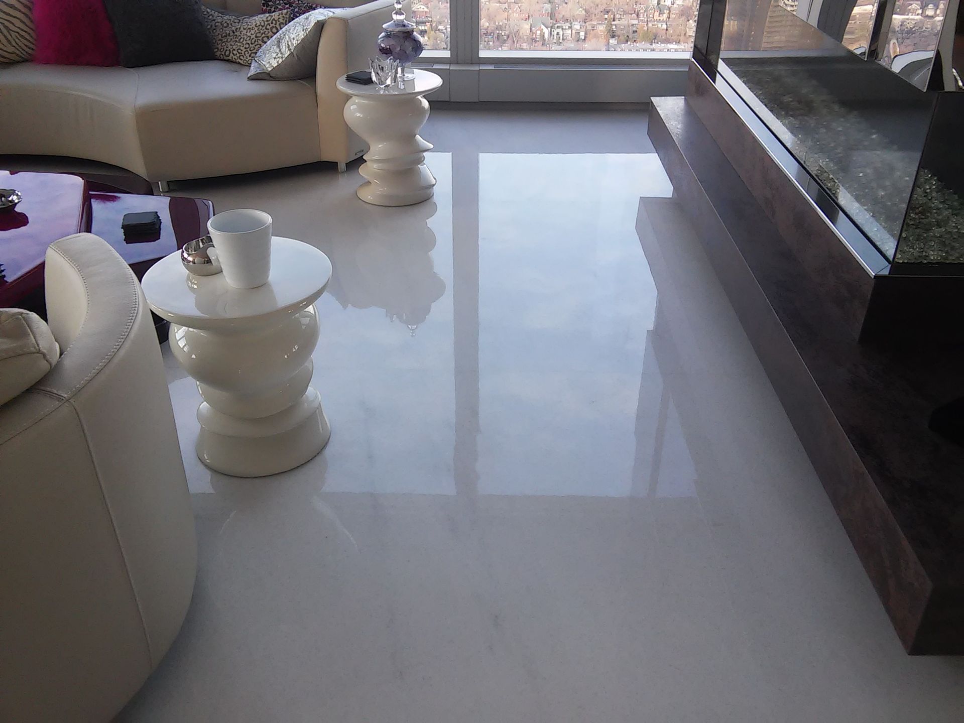 Shiny white tiled floor reflecting sunlight in a modern living room setting.