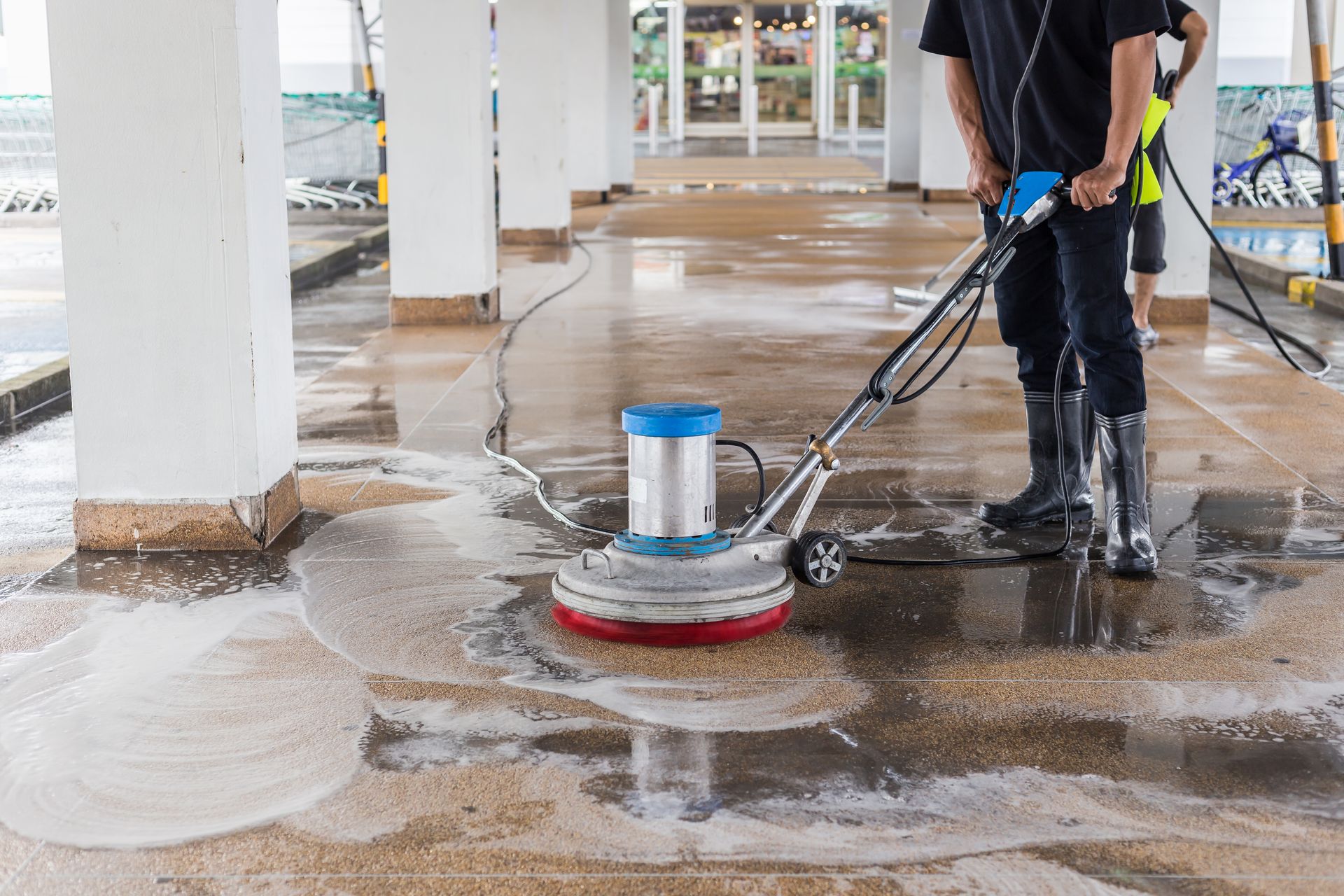 A man is cleaning the floor with a machine.