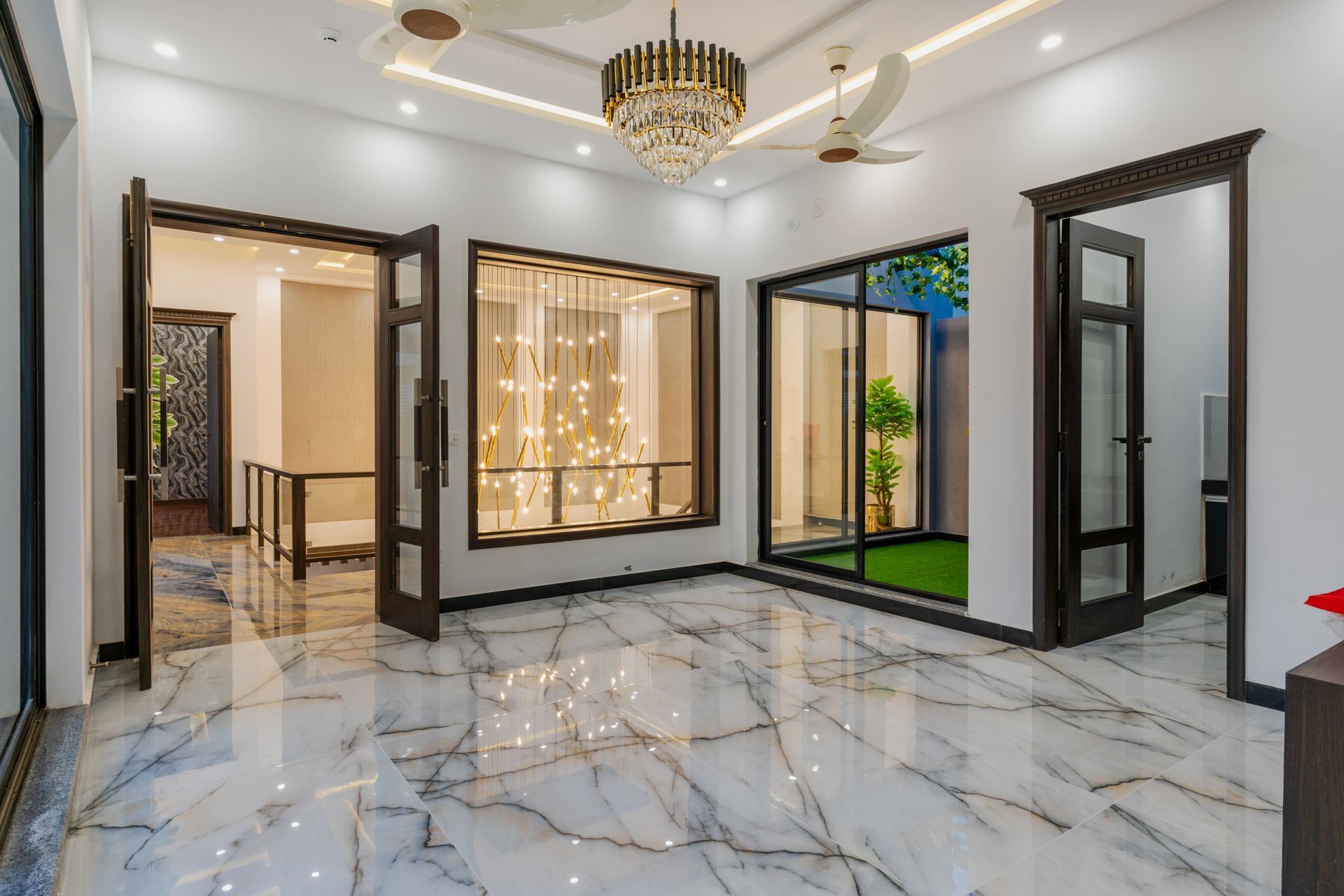 A large empty room with marble floors and a chandelier.