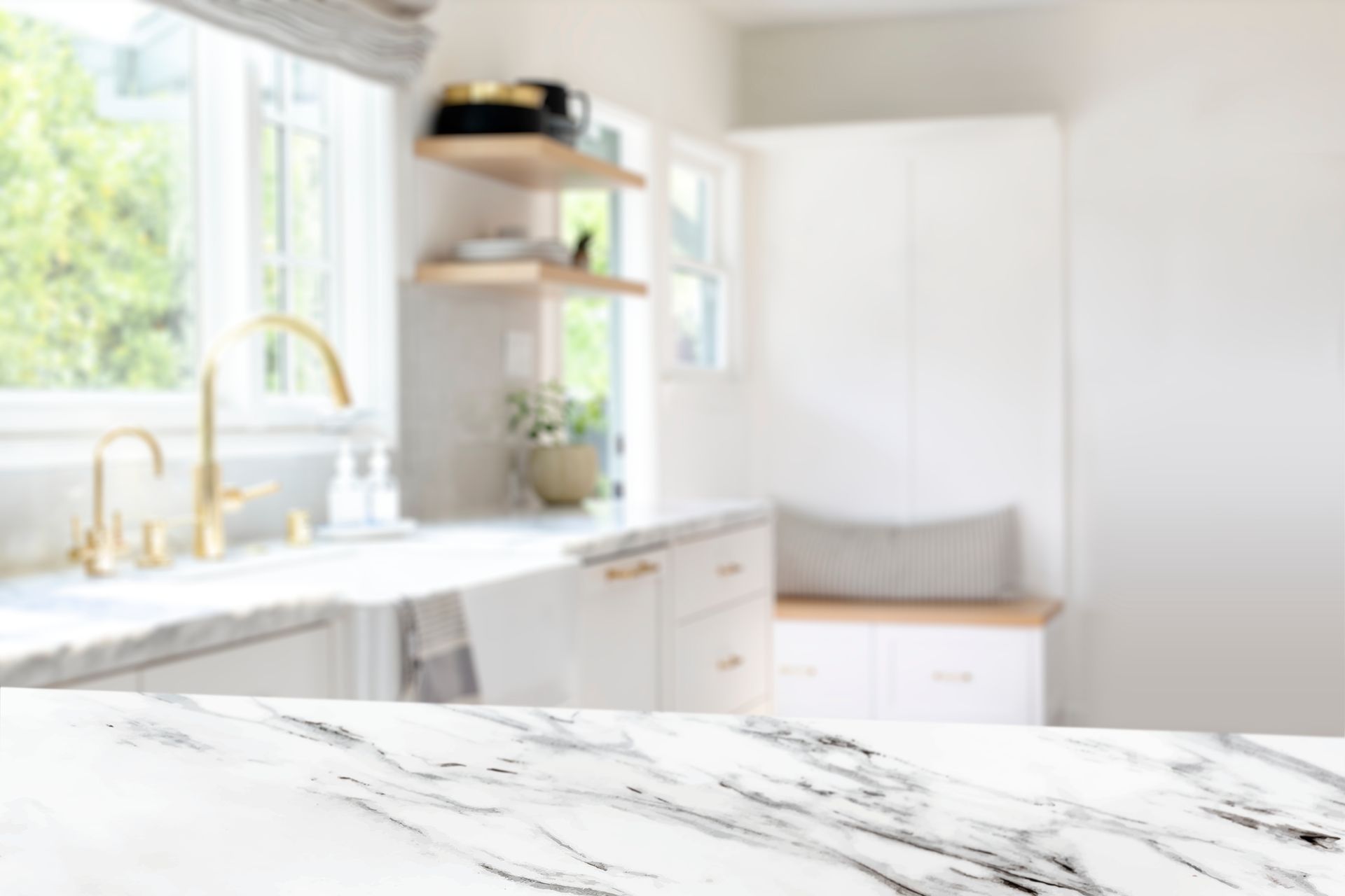 A kitchen with a marble counter top and a sink.