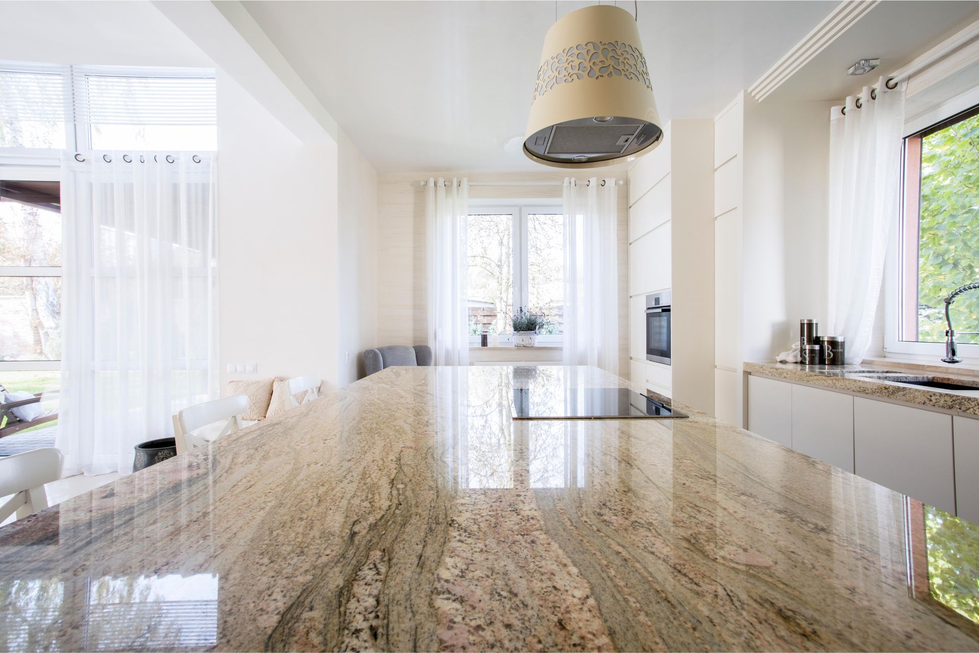 A kitchen with a large granite counter top and a stove top oven.