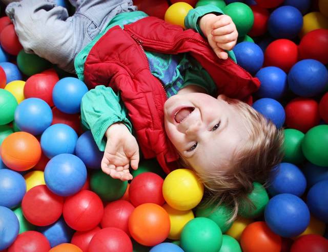 Bambino in vasca di palline colorate