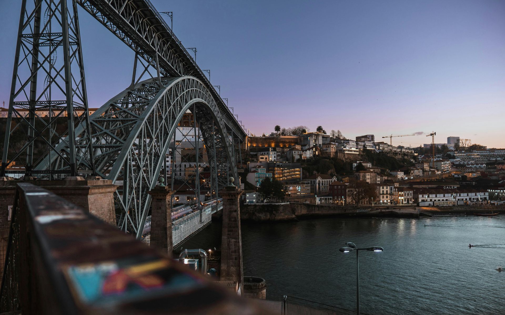 A bridge over a body of water with a city in the background.