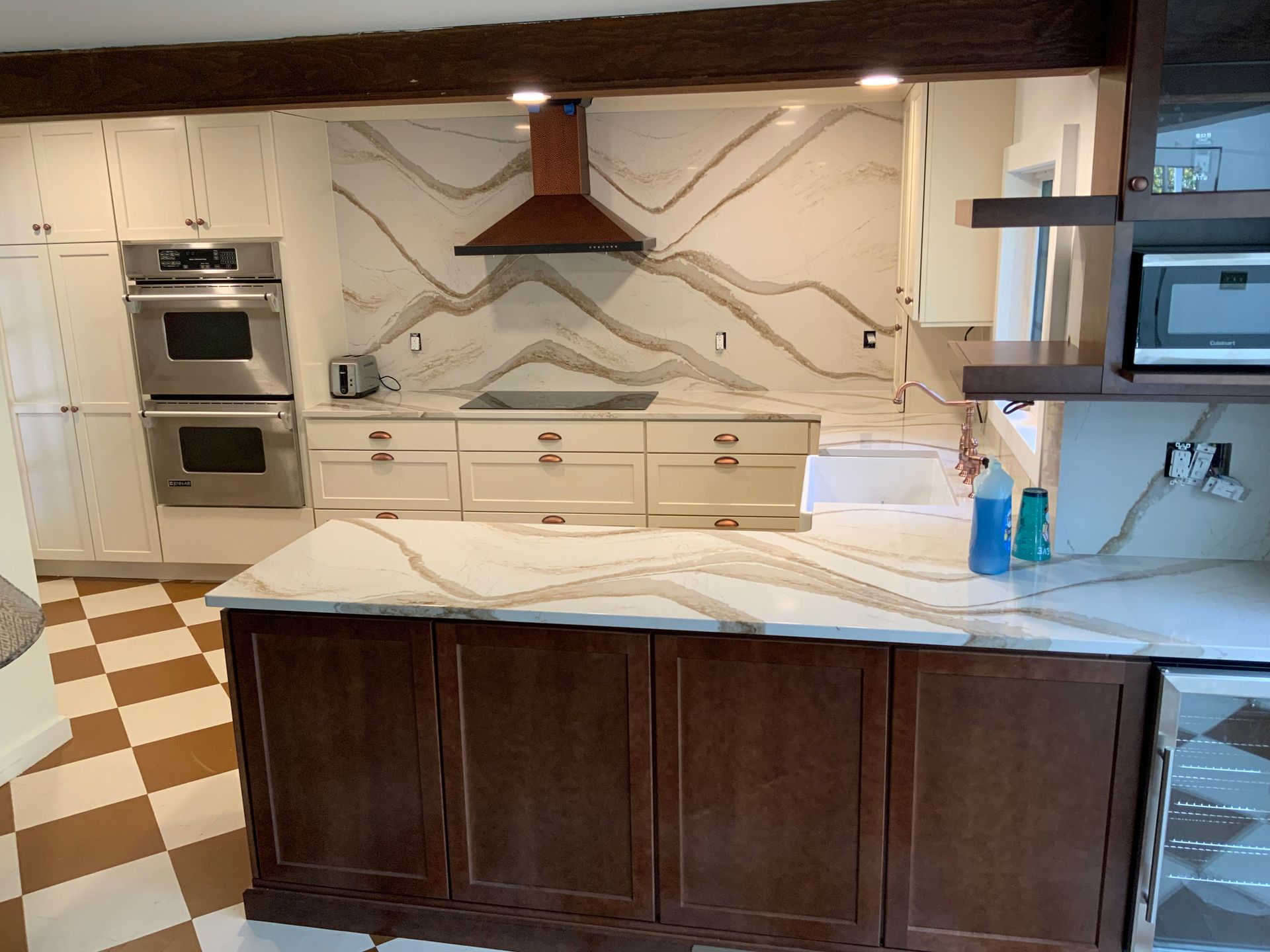 A kitchen with wooden cabinets and marble counter tops