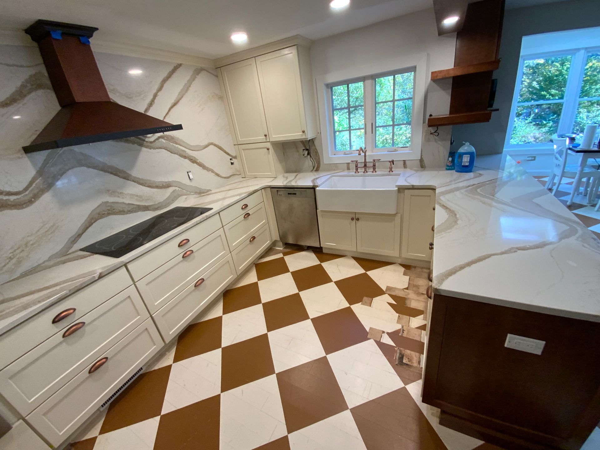 A kitchen with white cabinets and a checkered floor