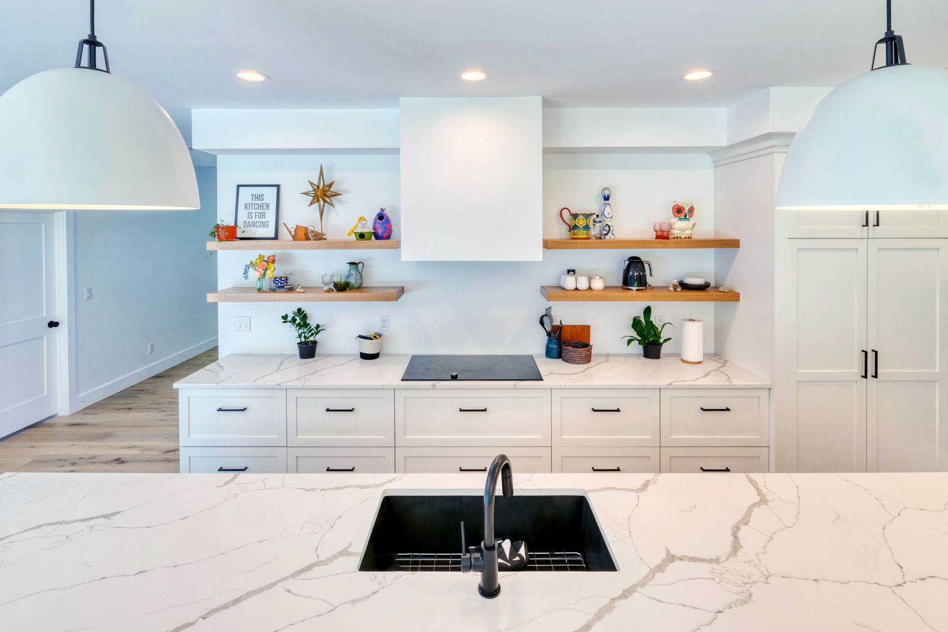 A kitchen with white cabinets and a black sink.