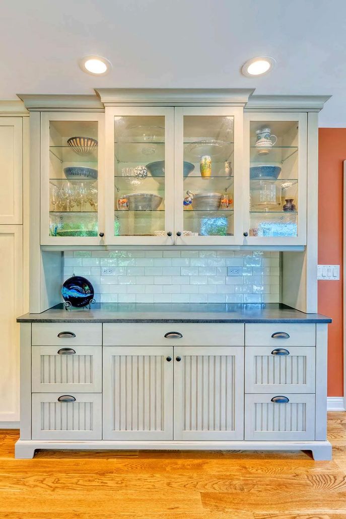 A white cabinet with glass doors and drawers in a kitchen. A white cabinet with glass doors and drawers in a kitchen.