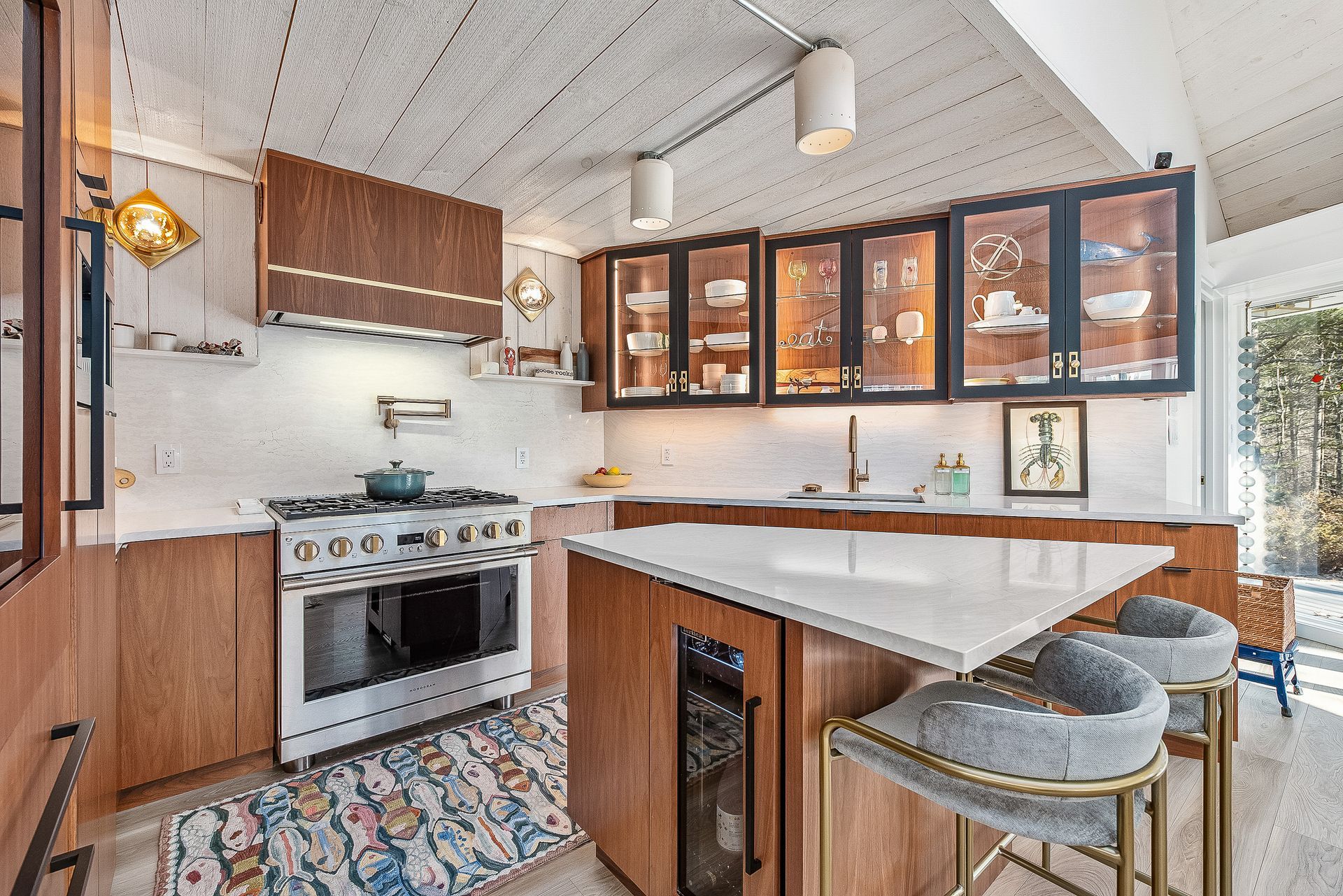 A kitchen with stainless steel appliances , wooden cabinets and a large island.
