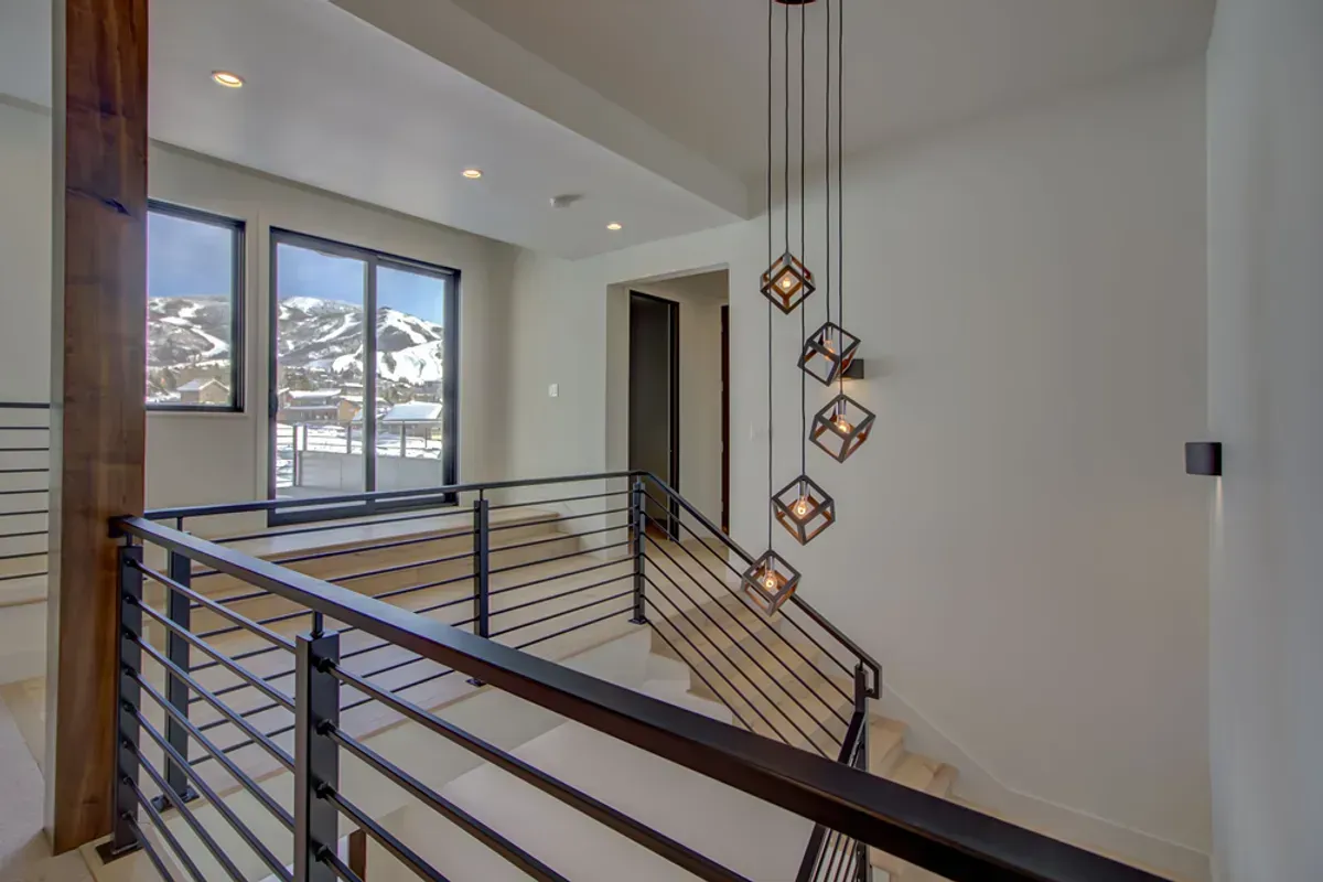 A staircase with a railing and a sliding glass door in a house.