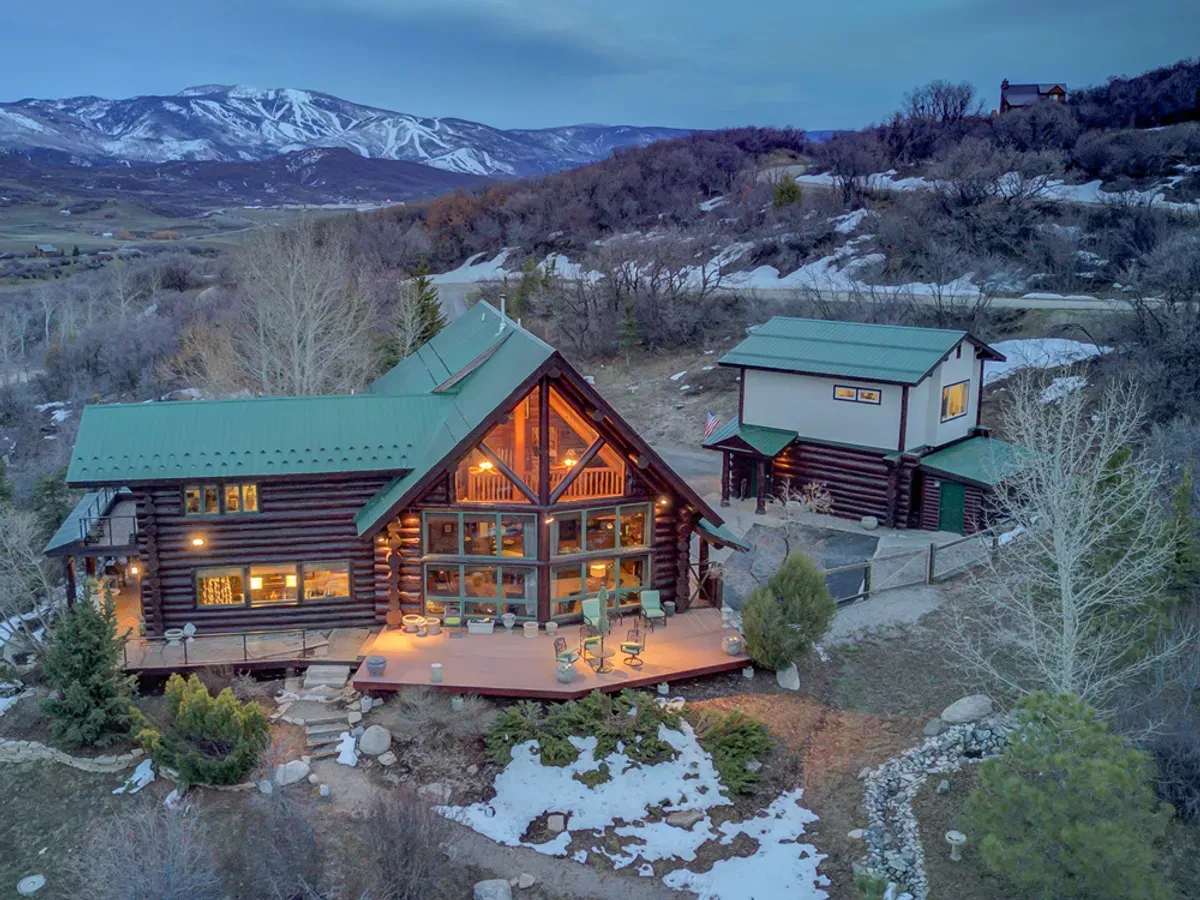 An aerial view of a log cabin in the mountains