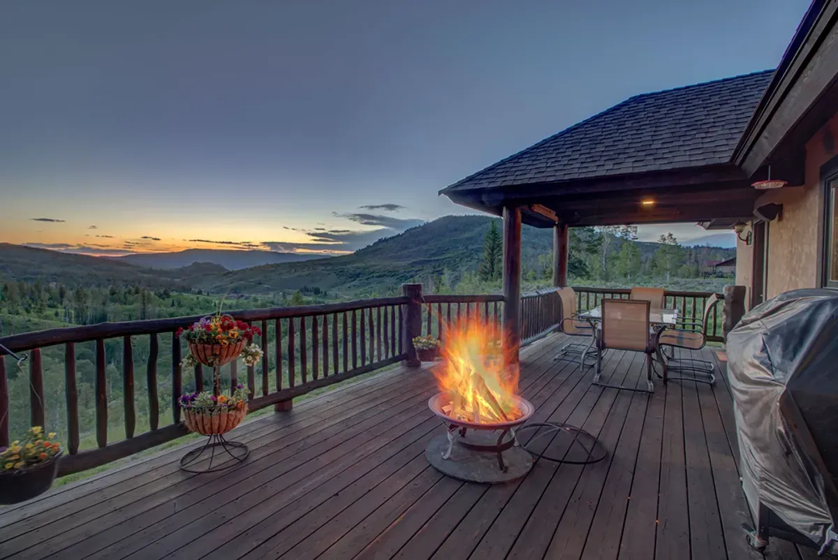 There is a fire pit on the deck of a house.