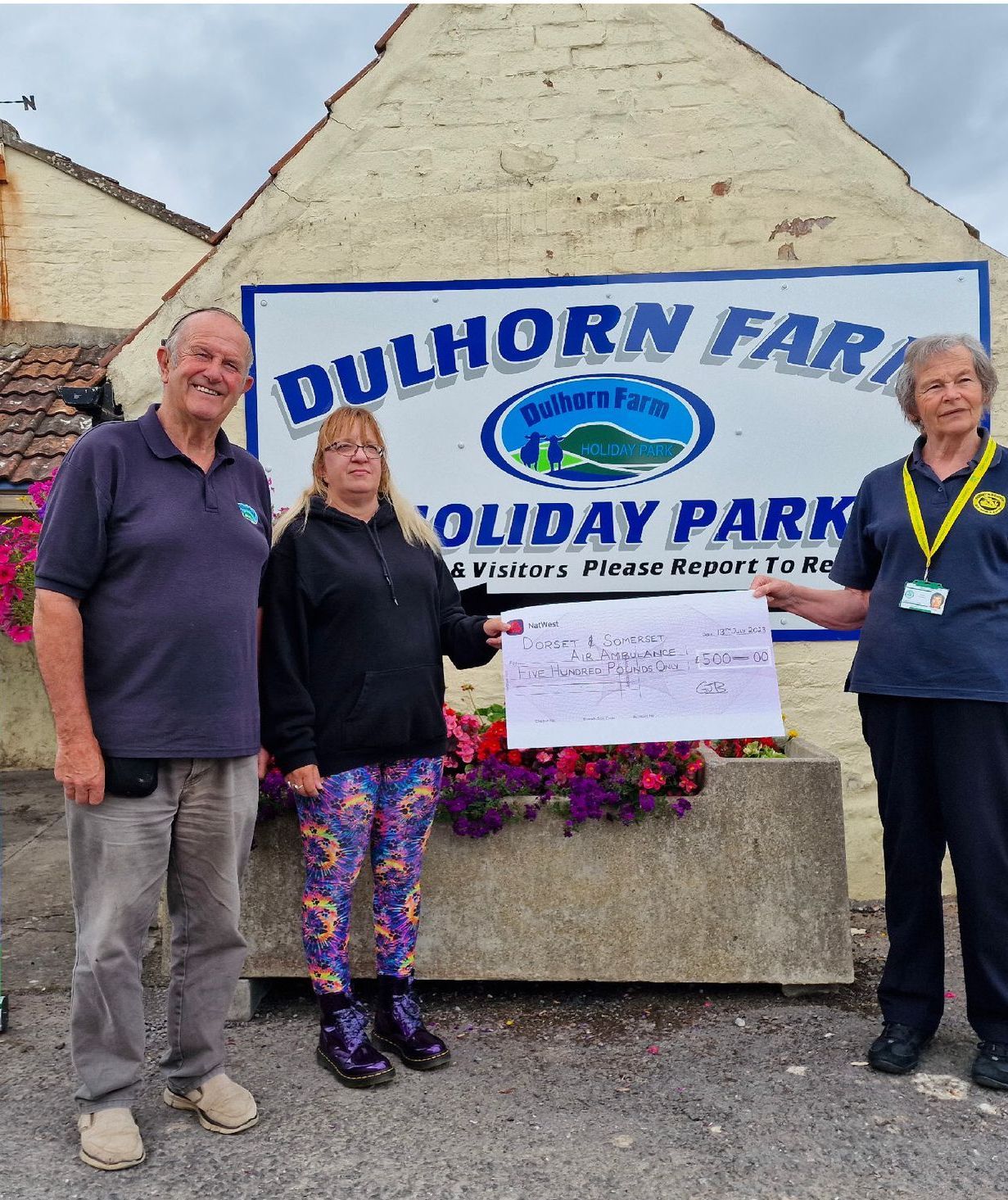 A group of people standing in front of a sign that says dulhorn farm