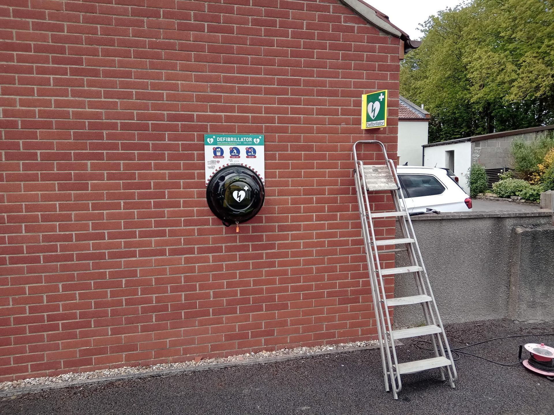 A ladder is sitting on the side of a brick wall.