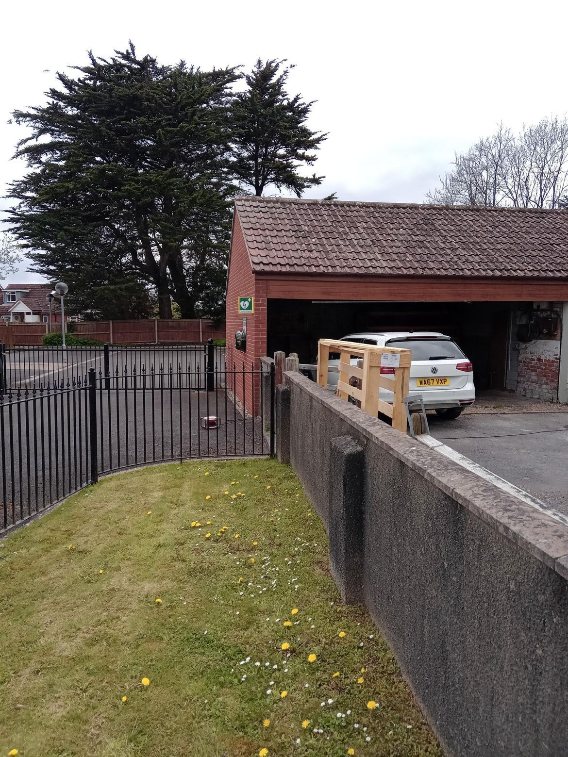 A car is parked in a garage next to a fence.