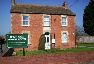 A brick house with a green sign that says brent area medical centre
