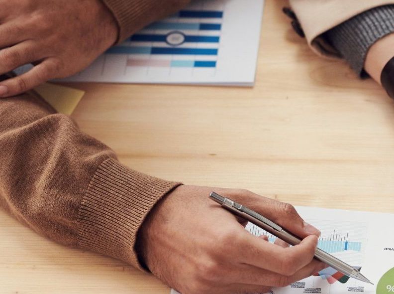 A person is writing on a piece of paper with a pen.