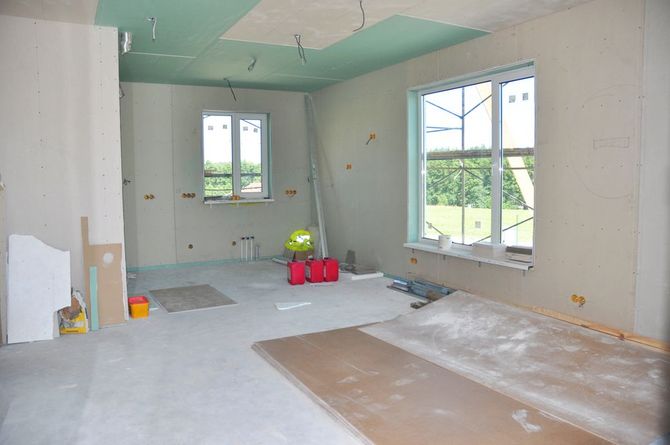 Interior room renovation with unfinished walls and ceiling.