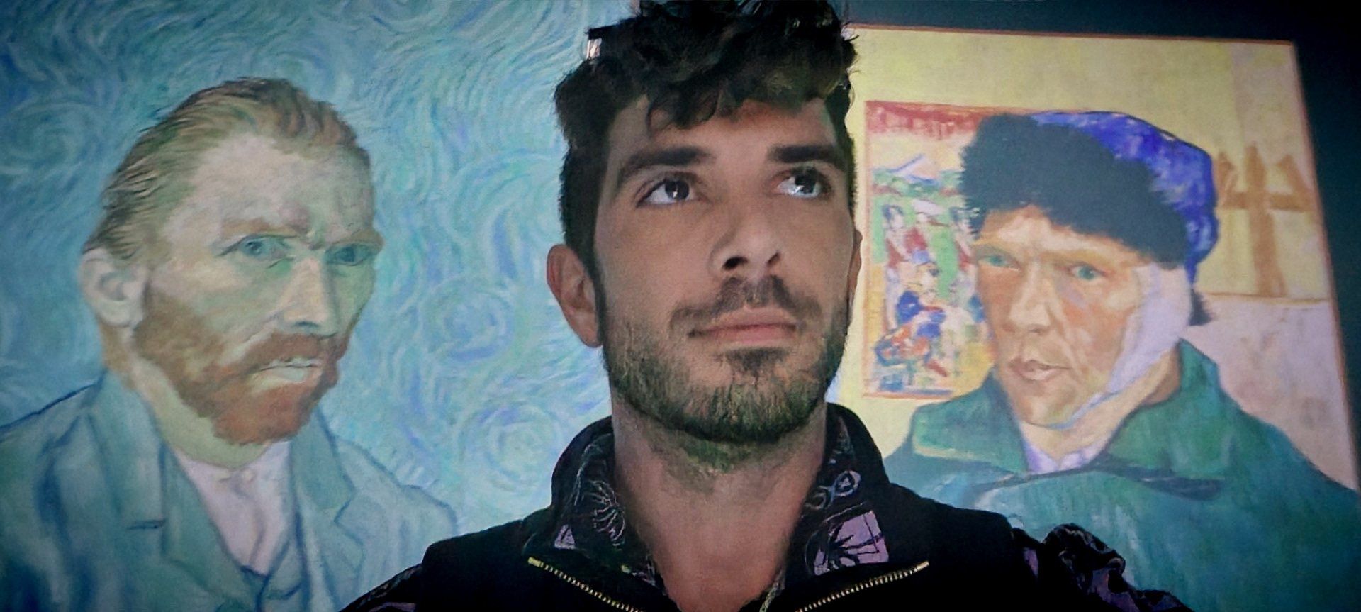 A man is standing in front of a painting of vincent van gogh.