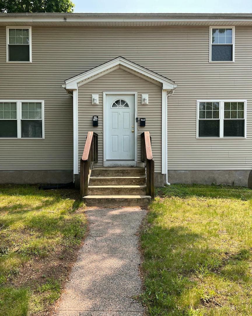 A house with a white door and stairs leading to it.