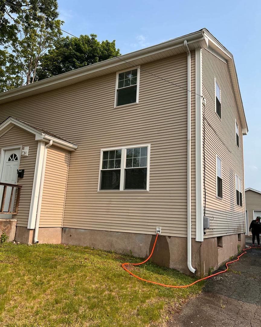 A house with a hose attached to the side of it.
