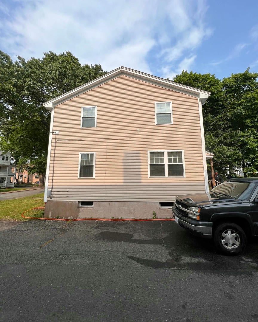 A black truck is parked in front of a house