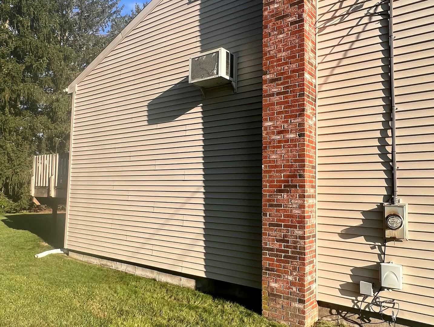 There is a brick chimney on the side of a house.