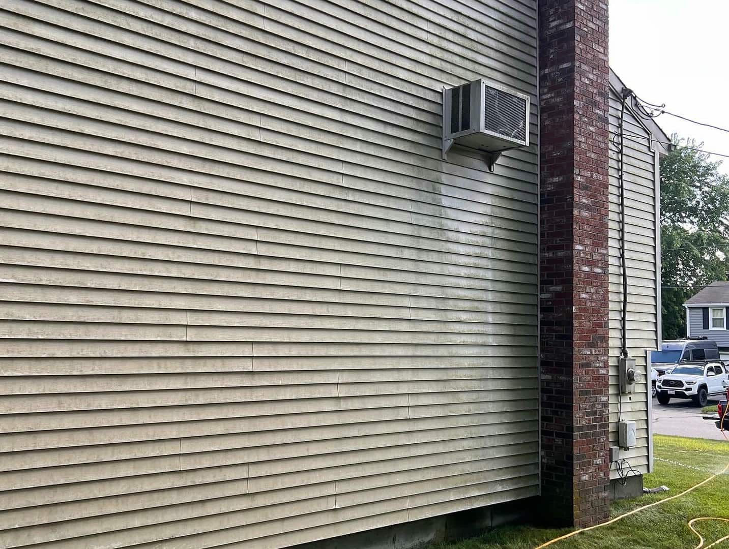 A house with a air conditioner on the side of it.