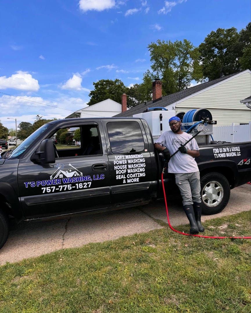 A man is standing next to a truck with a hose attached to it.