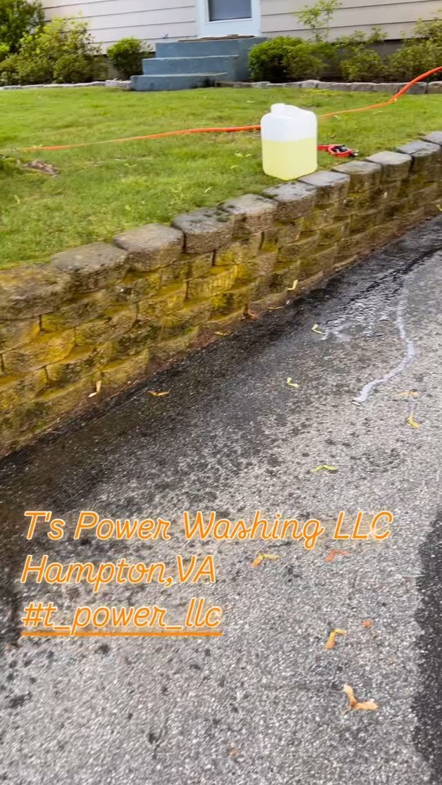 A bucket of soap is sitting on the side of the road next to a brick wall.