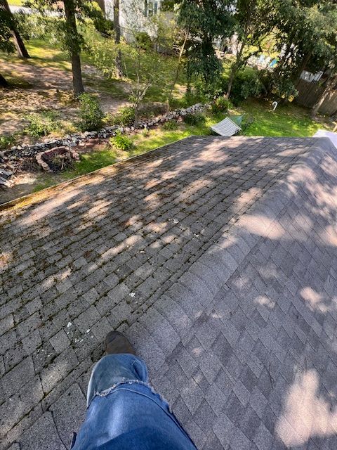 A person is standing on top of a brick roof.