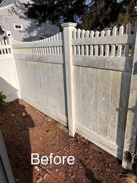 A picture of a white fence before being cleaned.