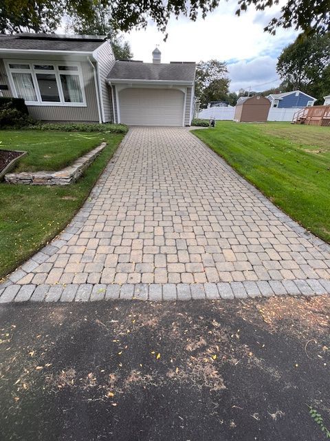 A driveway leading to a house with a white garage door