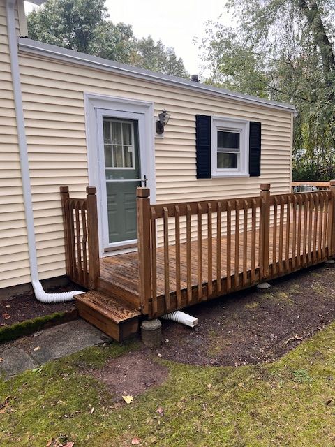 A small house with a wooden deck in front of it