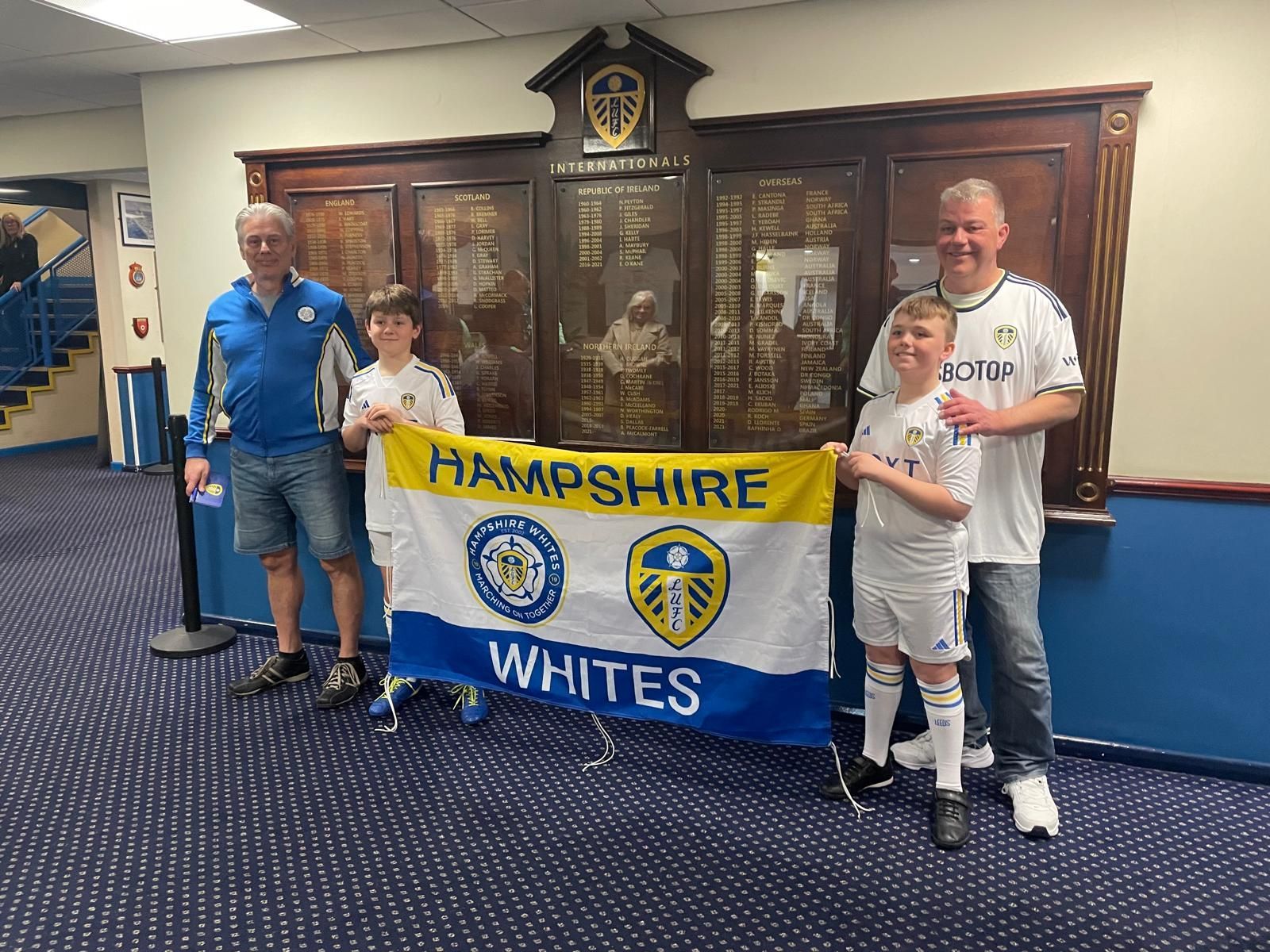 Sebastian and Daniel holding the Hampshire Whites flag alongside their proud parents
