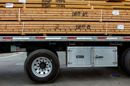 A truck with a stack of wood on the back of it