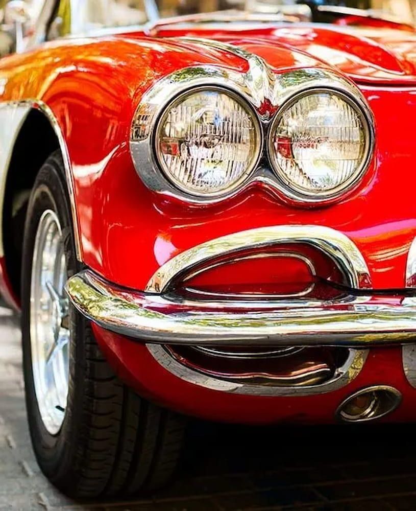 A Red Car With Chrome Trim is Parked on the Side of the Road — Seabreeze Auto Body in Coffs Harbour, NSW