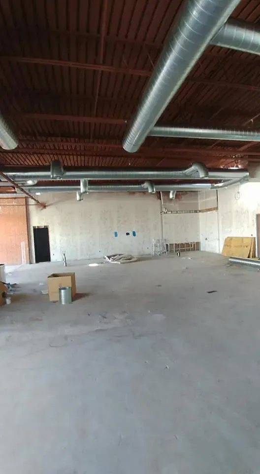 A large empty room with a lot of pipes coming out of the ceiling.