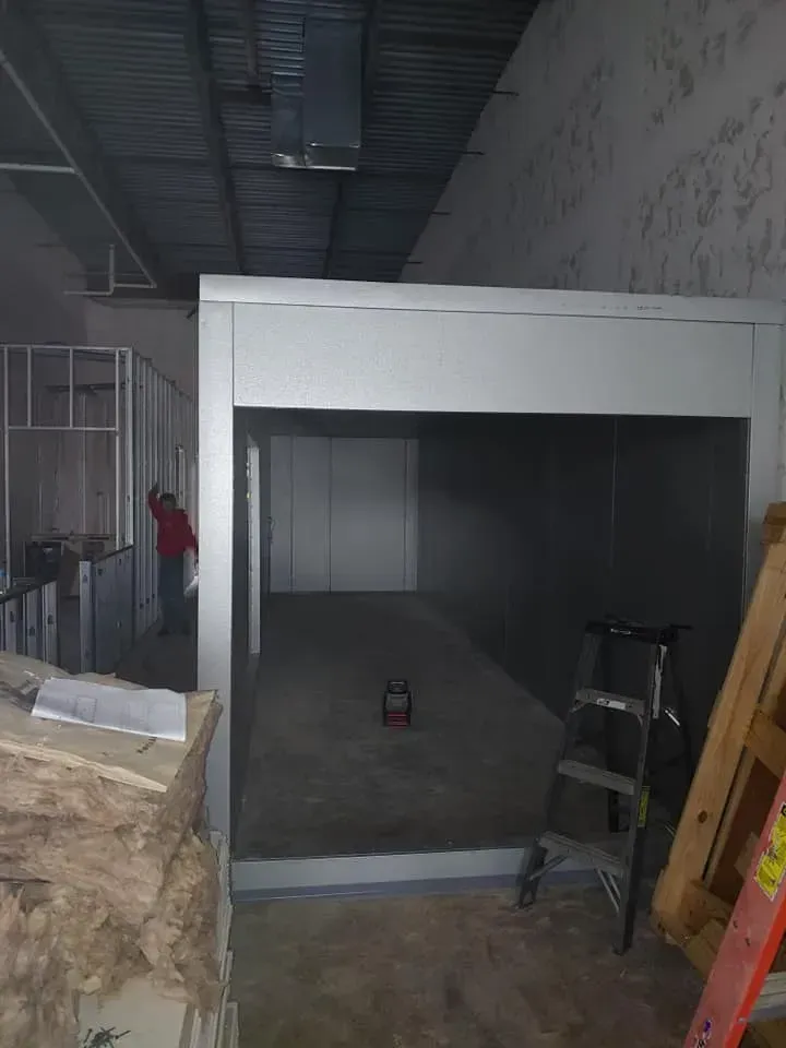 A man is standing in a room with a ladder in it.