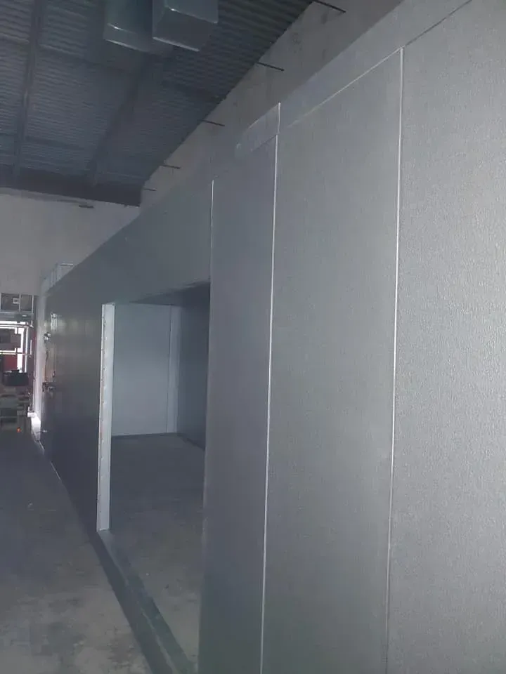 A long hallway with a lot of gray walls in a building.
