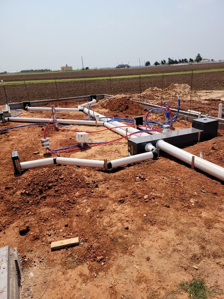 A construction site with a lot of pipes in the dirt