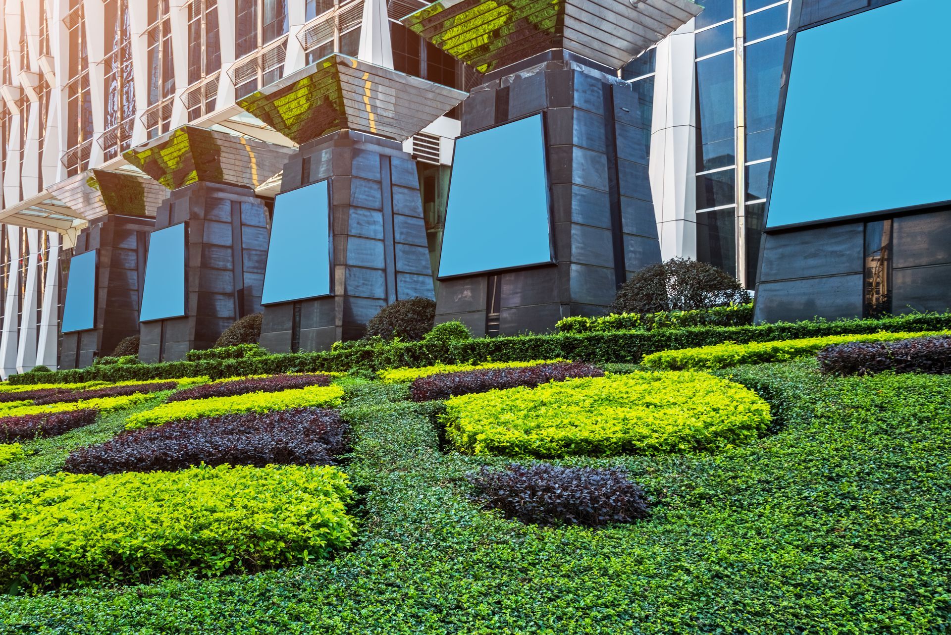A large building with a lot of plants and flowers in front of it.