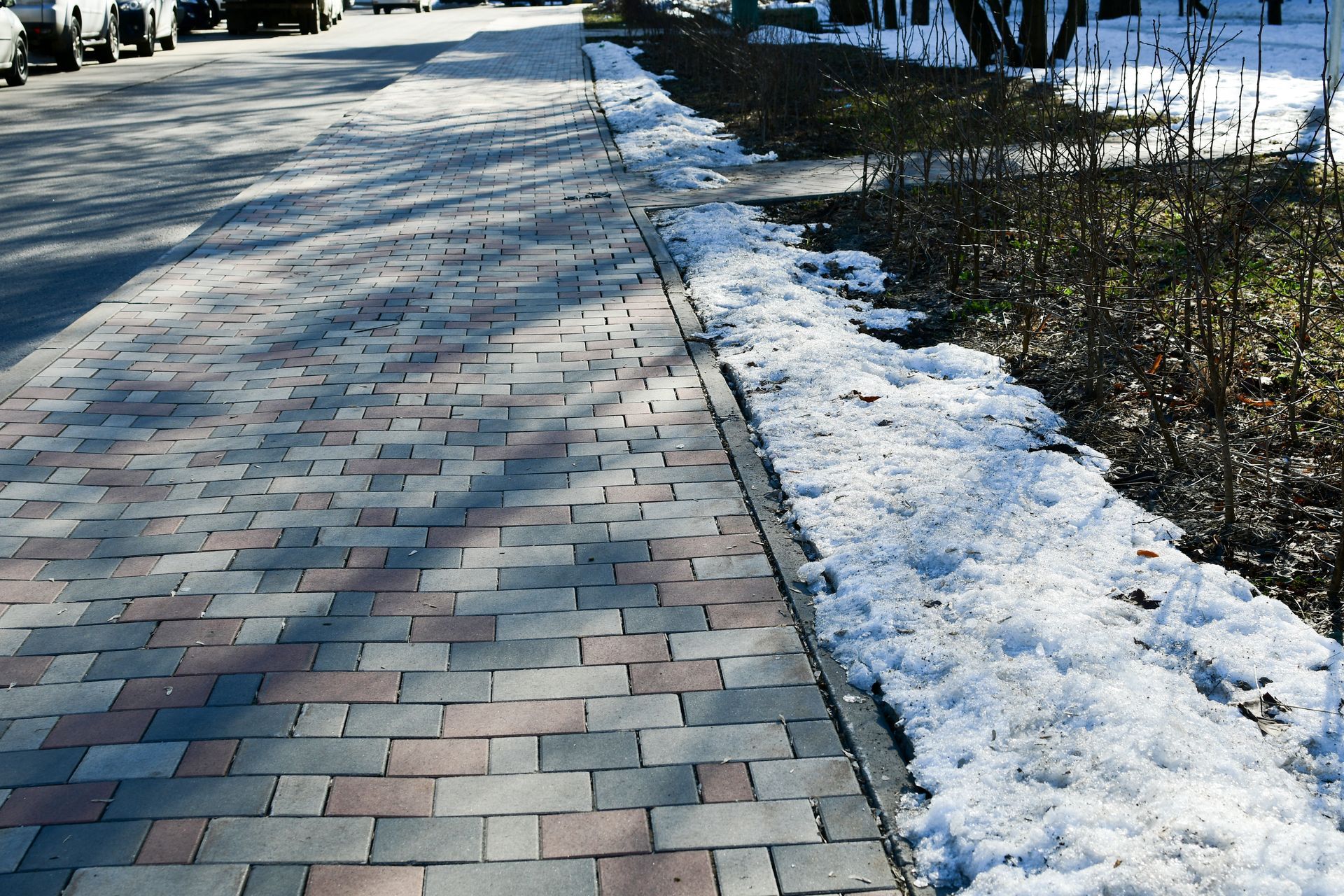 A sidewalk with snow on the side of it