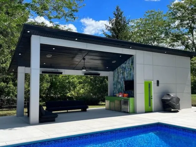 Modern outdoor kitchen with pool, seating, and green accents.