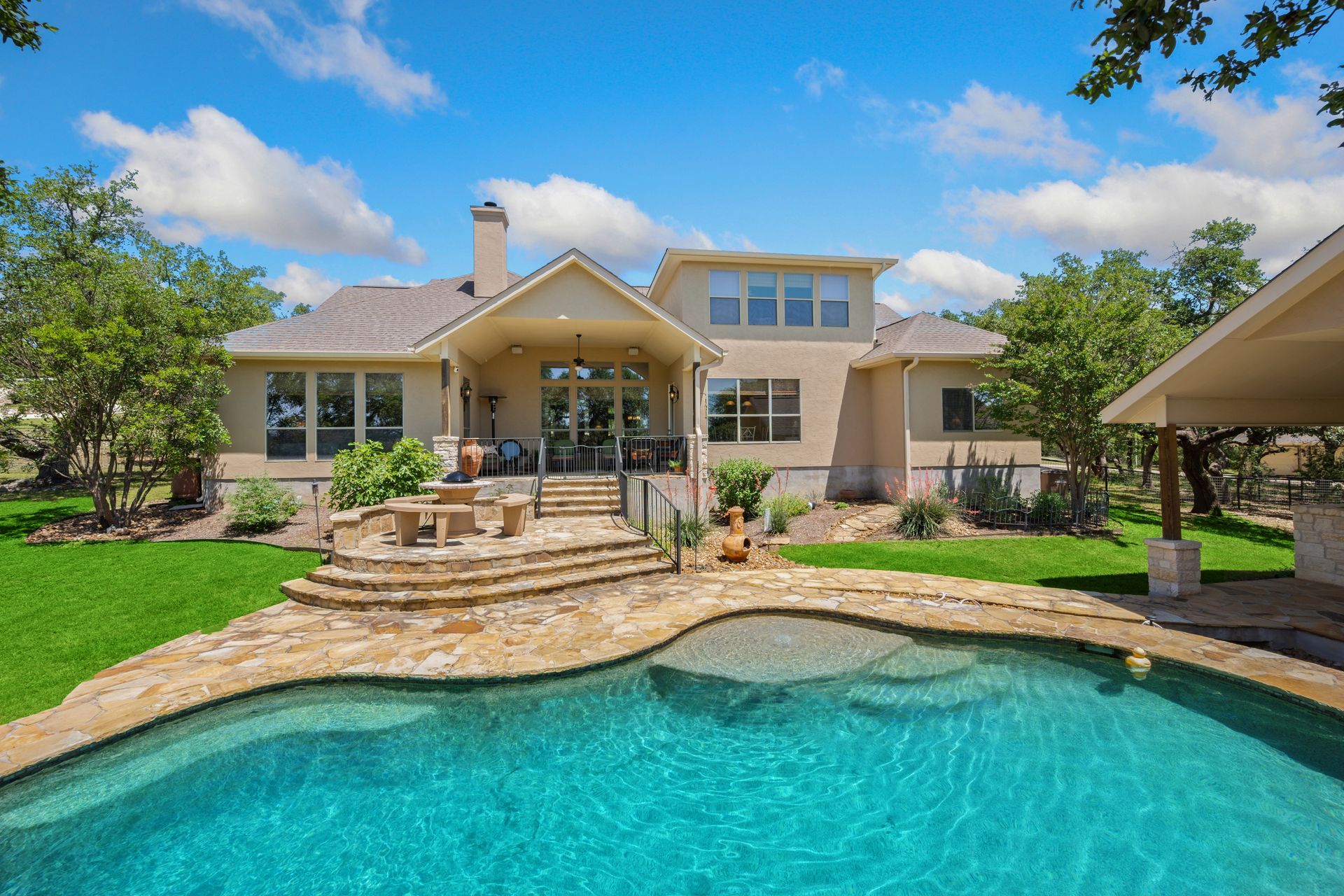 A large house with a large swimming pool in front of it.