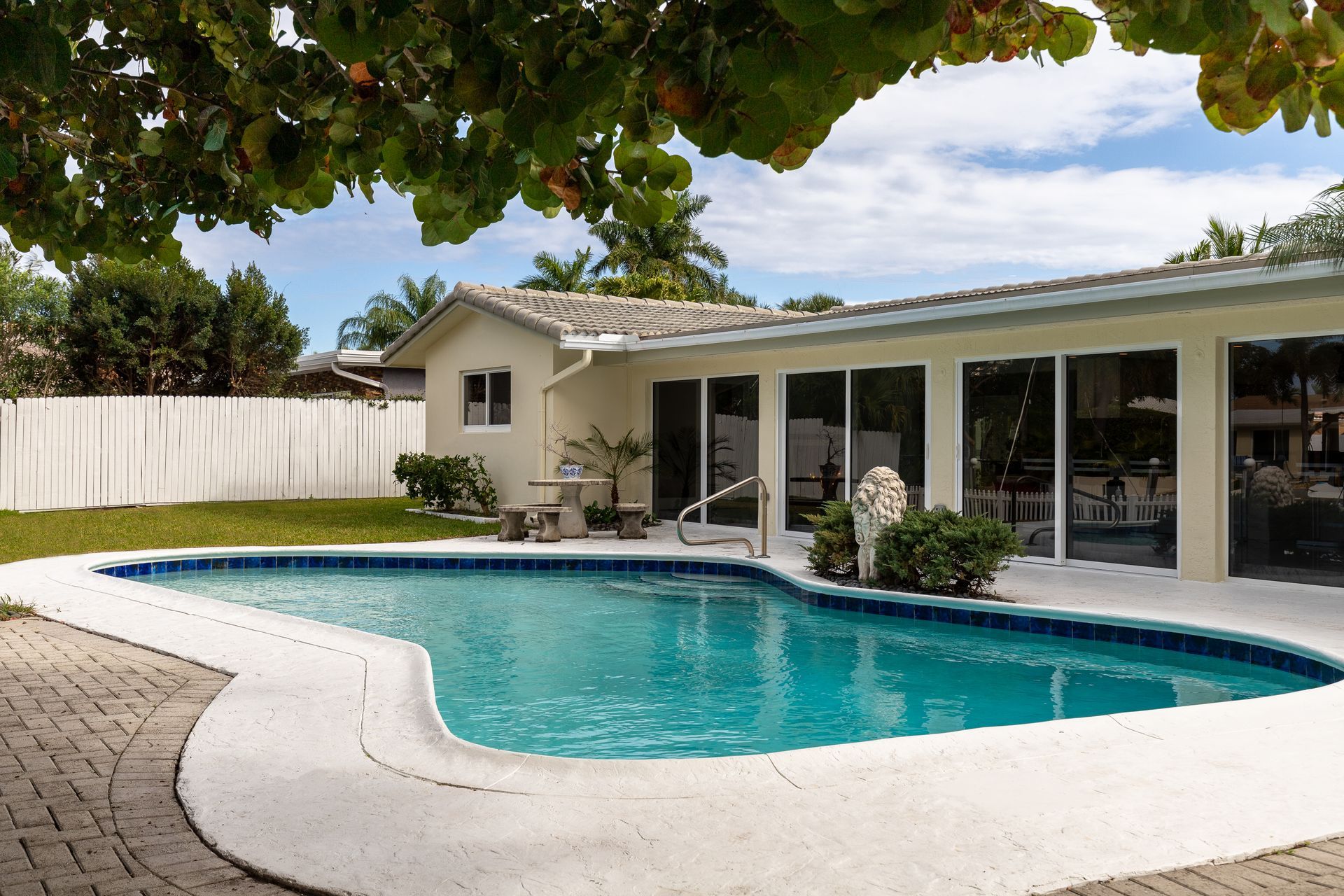 A house with a large swimming pool in front of it