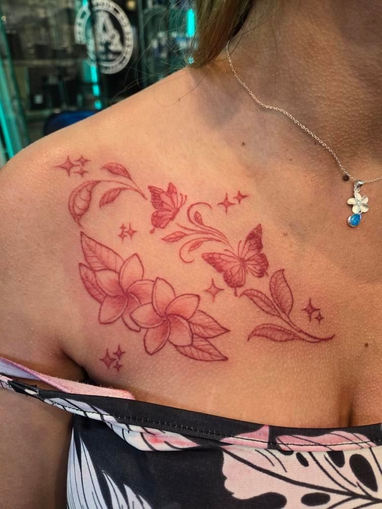 A woman has a tattoo of flowers and butterflies on her chest.
