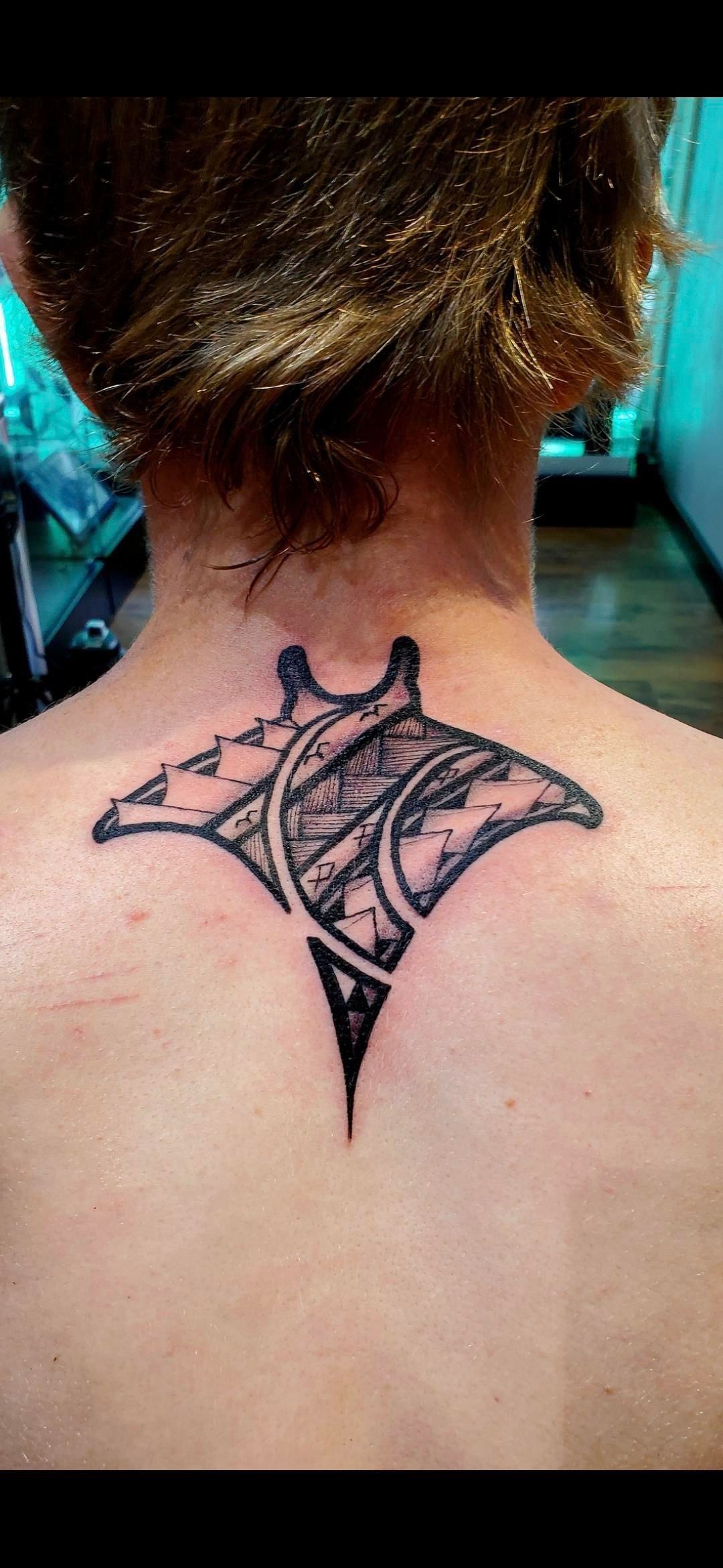 A woman has a manta ray tattoo on her back.