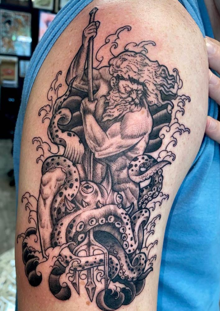 A man has a tattoo of a bearded man holding a cane