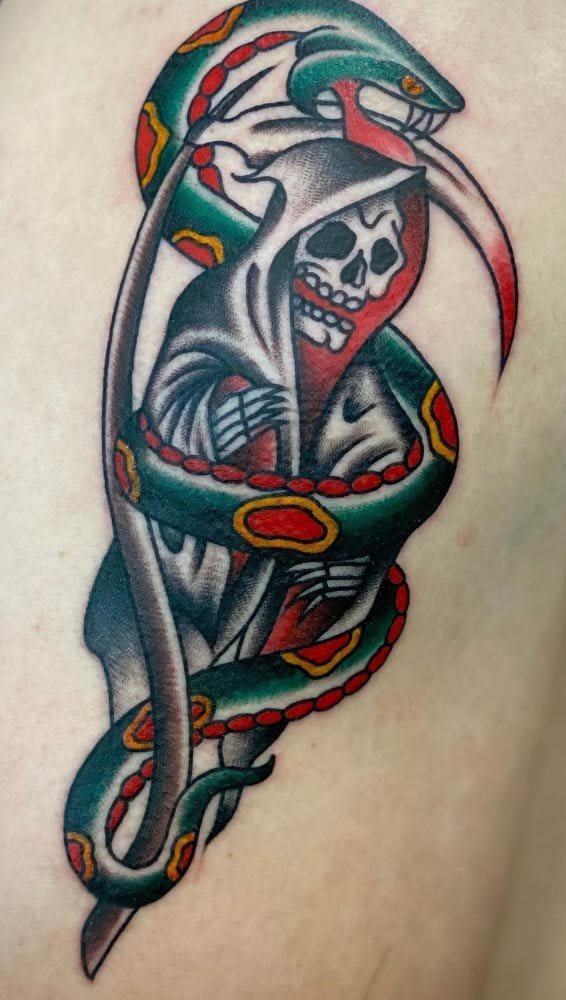 A tattoo of a grim reaper and a snake on a person 's back.